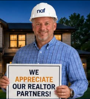 Brian Marchand in a New American Funding hard hat holding a sign that reads We Appreciate Our Realtor Partners